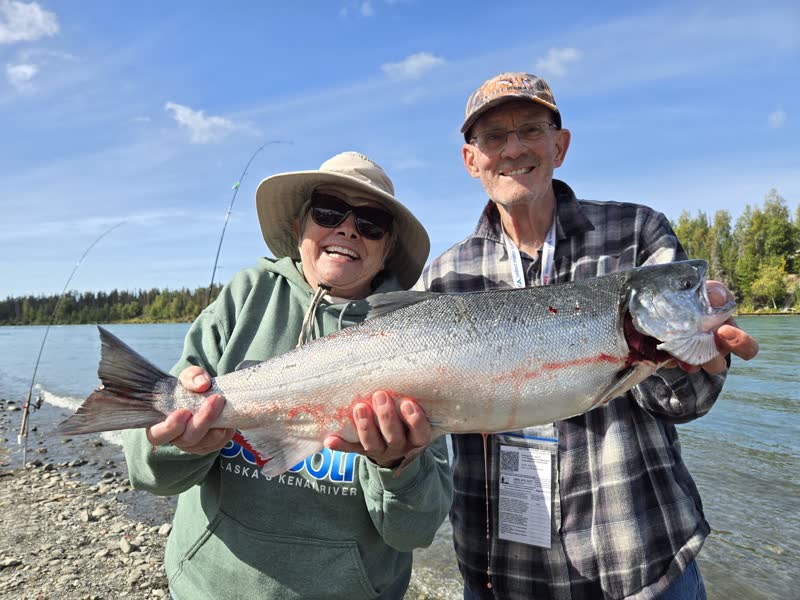 Anglers holding a big Kenai River sockeye salmon